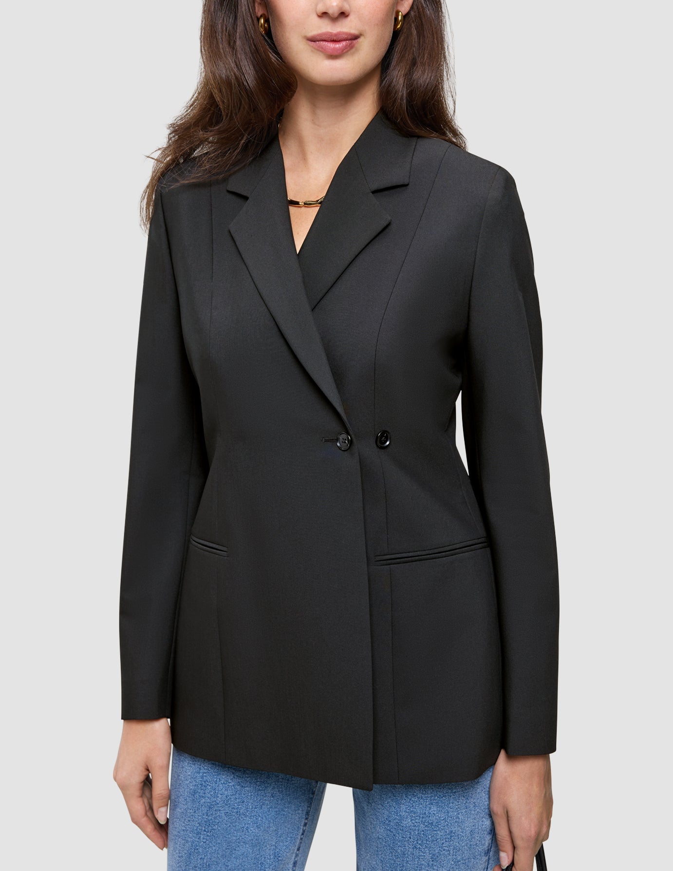 En person har en sort Avira-blazer til kvinder i dobbeltradet stil med spidse revers på over et par blå jeans.